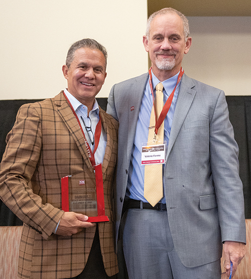 NMSU President Valerio Ferme, right, presents Davin Lopez, president and CEO of the Mesilla Valley Economic Development  Alliance, the Kevin B. Boberg Excellence in Economic Development Award at the NMSU Outreach Conference in November 2024.