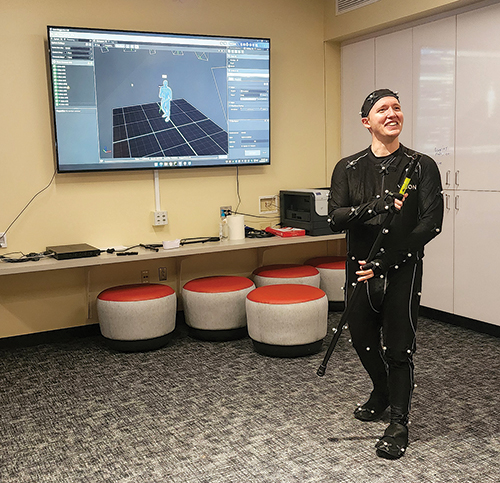 A volunteer exhibits an example of state-of-the-art technology game development and animation courses. The model displays how students utilize actual people during the animation and gaming process.