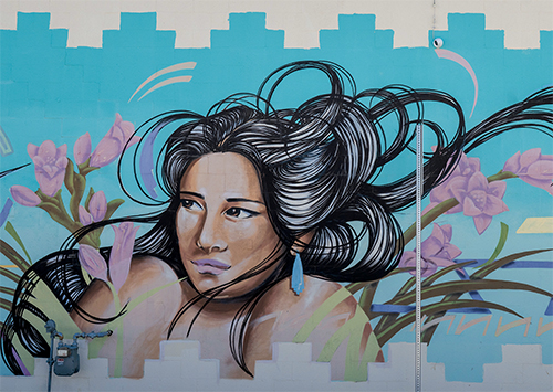 In downtown Las Cruces, “All Between Land and Air” depicts a woman with flowing hair surrounded by hummingbirds and plants.