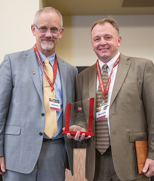  NMSU Agricultural Experiment Station Director Jay Lillywhite, right, accepts the Kevin B. Boberg Excellence in Economic Develop­ment Award from NMSU President Valerio Ferme at the NMSU Outreach Conference in November 2024.