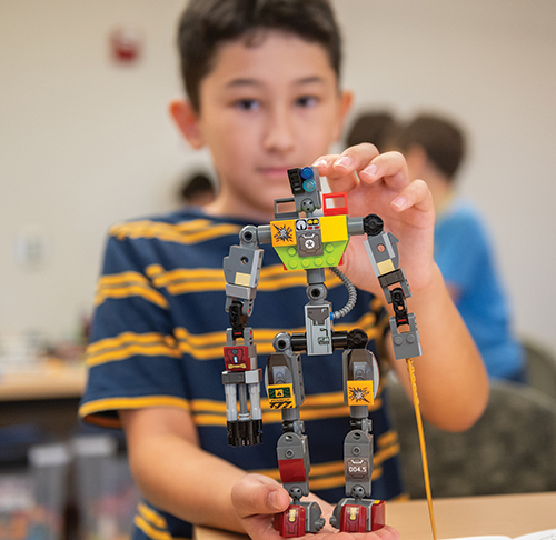 Mario Saenz operates a robot through an obstacle course as Gene Fretwell looks on. 