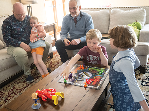 Lucy, right, and Dante play a game of Sorry! on the coffee table as Autumn snuggles with Giorgio Corda and Valerio Ferme watches the fun.