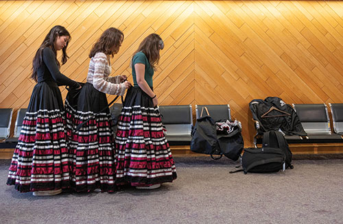  Mariah Leonard, Sophie Ostos and Alicia Diaz help each other with their folklórico dresses.