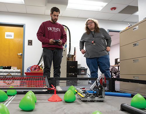 Mario Saenz operates a robot through an obstacle course as Gene Fretwell looks on. 