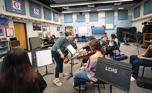 Top: Jennifer Rogers, Las Cruces High School orchestra director, was named the New Mexico Music Educators Association Educator of the Year and received a 2025 National Federation of High School Associations Outstanding Music Educator Award. Bottom: Rogers works with an ensemble during a rehearsal.